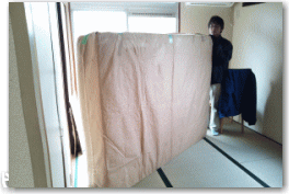 ベッドマットカバーをかけてから引越し作業するスタッフ